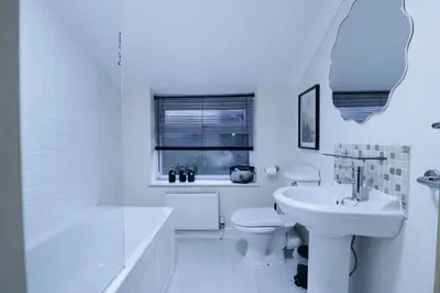 a white bathroom with a tub and a toilet and a sink at Stylish & Cosy Stay 2-Bed House Train Station Hospital Garden Fast WiFi in Colchester