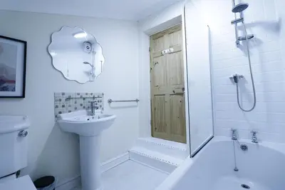 a white bathroom with a shower and a sink at Stylish & Cosy Stay 2-Bed House Train Station Hospital Garden Fast WiFi in Colchester