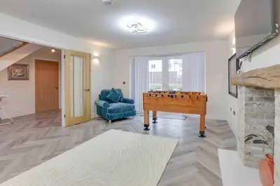 a living room with a pool table and a blue chair at Kestrel Gardens Five Bedroom Homes in Great Dunmow