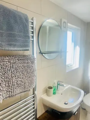 a bathroom with a sink and a mirror at Stunning 2 bedroom flat for 5 people overlooking the sea 2A in Felixstowe
