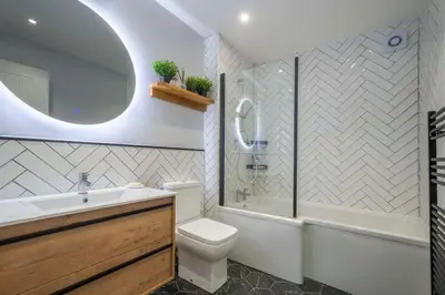 a bathroom with a toilet and a tub and a sink at 16 Waterloo Close, Newmarket in Newmarket