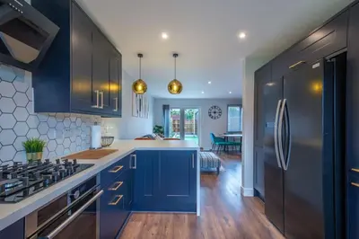 a kitchen with blue cabinets and a stove top oven at 16 Waterloo Close, Newmarket in Newmarket