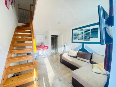 a living room with a staircase and a couch at The Mews Flats - Cambridge, Central Location CB1 in Cambridge