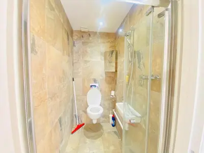 a bathroom with a toilet and a glass shower at The Mews Flats - Cambridge, Central Location CB1 in Cambridge