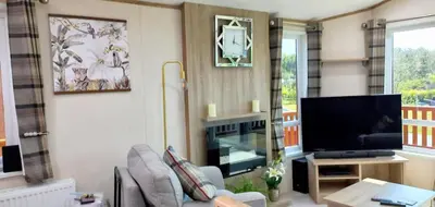 a living room with a couch and a tv at Amazing Lodge with Hot Tub in Stowmarket