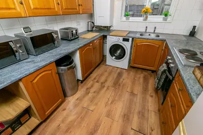 a kitchen with a sink and a washing machine at Parkview Guesthouse in Graveley