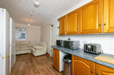 a kitchen with wooden cabinets and a counter top with a microwave at Parkview Guesthouse in Graveley