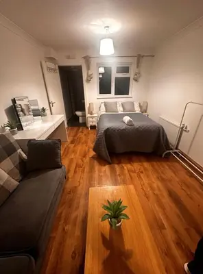 a living room with a bed and a couch at Parkview Guesthouse in Graveley