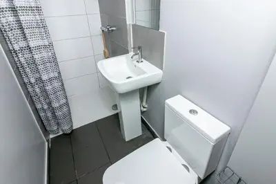 a white bathroom with a toilet and a sink at Parkview Guesthouse in Graveley