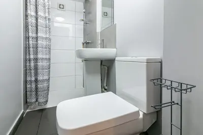 a white bathroom with a toilet and a sink at Parkview Guesthouse in Graveley