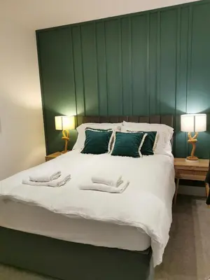 a bedroom with a large bed with two towels on it at No 13 Colchester Town Flat with Kitchen & Parking in Colchester
