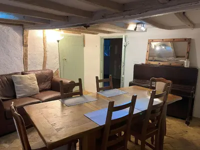 a living room with a wooden table and a couch at 15th Century Thatched Cottage in Cambridge