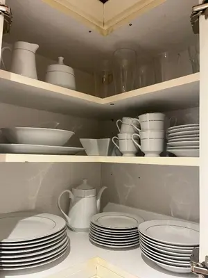 a cabinet filled with plates and cups and dishes at 15th Century Thatched Cottage in Cambridge