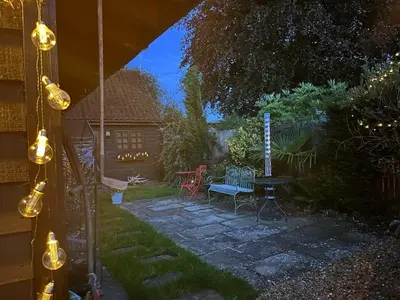 a backyard with a table and chairs and a picnic table at 15th Century Thatched Cottage in Cambridge