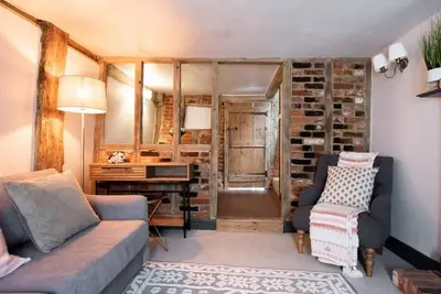 a living room with a couch and a desk at Norsey Cottage Billericay in Billericay