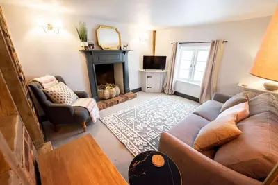 a living room with a couch and a fireplace at Norsey Cottage Billericay in Billericay