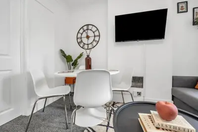 a living room with a table and chairs and a tv at Wherstead Rd House By Homestyles Hosts Short Lets & Serviced Accommodation Suffolk With Free Parking in Ipswich