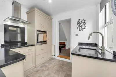 a kitchen with white cabinets and a sink in it at Wherstead Rd House By Homestyles Hosts Short Lets & Serviced Accommodation Suffolk With Free Parking in Ipswich