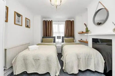 two beds in a room with white walls at Wherstead Rd House By Homestyles Hosts Short Lets & Serviced Accommodation Suffolk With Free Parking in Ipswich