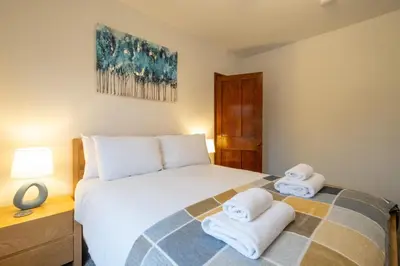 a bedroom with a bed with towels on it at 10 Jubilee Cottage in Leiston