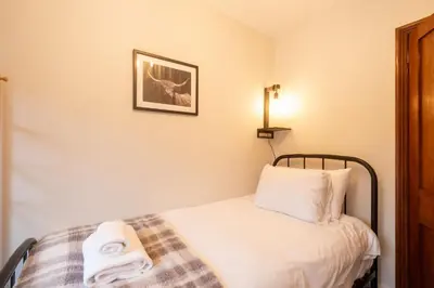 a bedroom with a bed with two towels on it at 10 Jubilee Cottage in Leiston