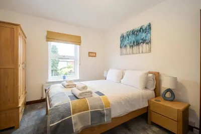 a bedroom with a bed with towels on it at 10 Jubilee Cottage in Leiston