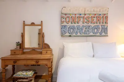 a bedroom with a bed and a mirror and a table at 3 Uplands, Thorpeness - Sleeps 3, Close to Beach, Boating Lake, Thorpeness Golf Club and Country Club - Aldeburgh Coastal Cottages in Thorpeness