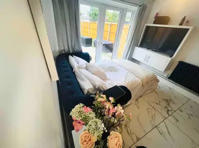 a bedroom with a bed with flowers on a table at Three bedroom house in Harlow
