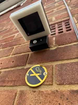 a no smoking sign on the side of a brick building at Three bedroom house in Harlow