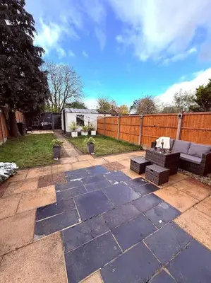 a patio with a couch and a table in a yard at Three bedroom house in Harlow