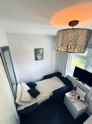 a small bedroom with a bed and a window at Three bedroom house in Harlow