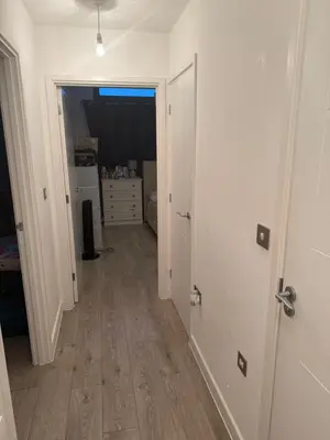 a hallway with white walls and wooden floors in a room at Station stay in Harlow