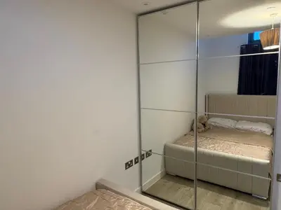 a room with a glass partition with a bed in it at Station stay in Harlow