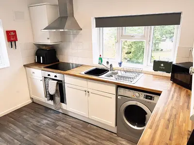 a kitchen with a sink and a washing machine at Comfortable 2-Bed Home, Perfect for Work and Leisure in Colchester in Colchester