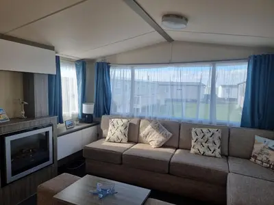 a living room with a couch and a large window at HAPs Holiday Home - Haven The Orchards in Brightlingsea