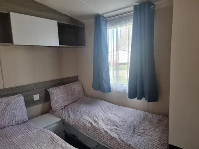 a small room with two beds and a window at HAPs Holiday Home - Haven The Orchards in Brightlingsea