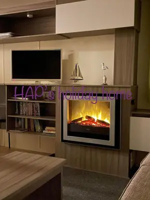 a living room with a fireplace and a tv at HAPs Holiday Home - Haven The Orchards in Brightlingsea