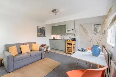 a living room with a couch and a table at 2 Lion Cottages, Knodishall in Leiston