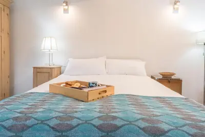 a bedroom with a bed with a wooden box on it at 2 Lion Cottages, Knodishall in Leiston