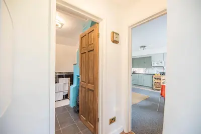 a hallway with a door leading to a kitchen at 2 Lion Cottages, Knodishall in Leiston