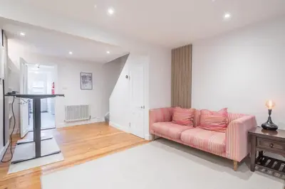 a living room with a pink couch and a table at Beautiful 2Bed cottage nr City in Cambridge