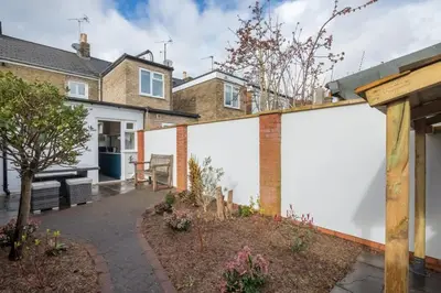 a house with white walls and a courtyard at Beautiful 2Bed cottage nr City in Cambridge