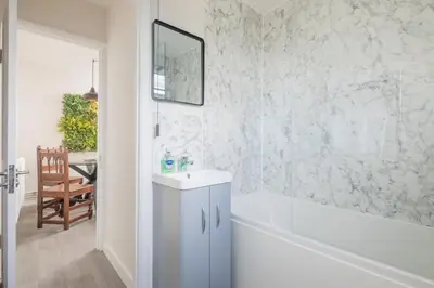a white bathroom with a tub and a sink at Beautiful 2Bed cottage nr City in Cambridge