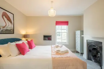 a bedroom with a large white bed with pink pillows at Beautiful 2bed Central Home in Cambridge