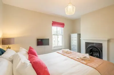 a bedroom with a bed with two cats laying on it at Beautiful 2bed Central Home in Cambridge