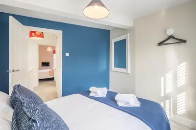 a blue bedroom with a bed with two pillows on it at Beautiful 2bed Central Home in Cambridge