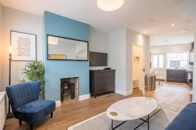a living room with a blue wall with a fireplace at Beautiful 2bed Central Home in Cambridge