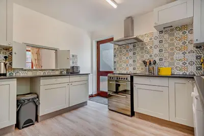 a large kitchen with white cabinets and a stove at 4 Bed in Woodbridge oc-s27356 in Martlesham