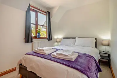 a bedroom with a bed with towels on it at 4 Bed in Woodbridge oc-s27356 in Martlesham
