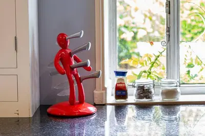 a red statue sitting on a counter next to a window at Hill House Norfolk in Saxlingham Nethergate